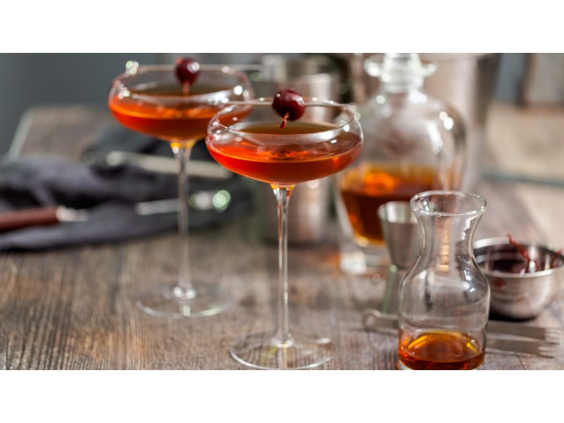 Reddish-brown cocktail with cherries