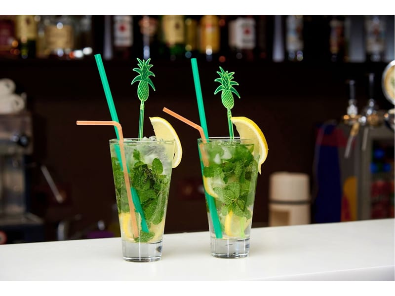 Mojito with ice and bright straws on the bar
