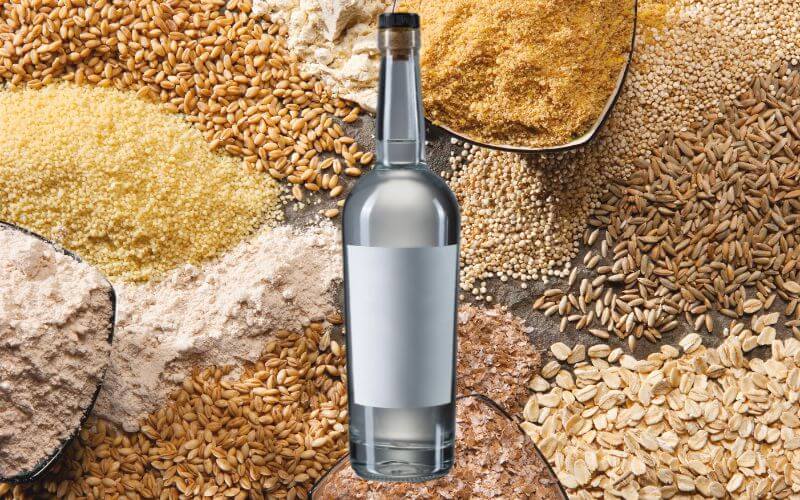 A bottle of grain alcohol in a background of assorted grains