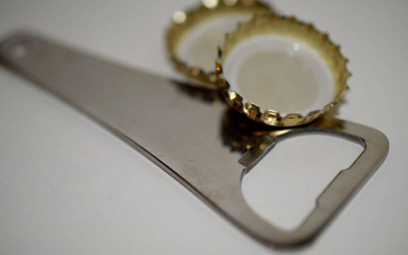 A bottle opener with two bottle caps