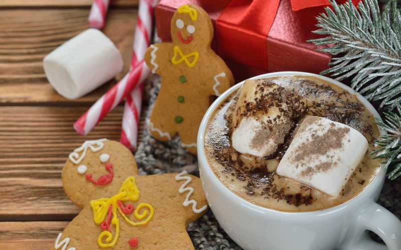 A cup of gingerbread hot chocolate with marshmallows and gingerbread man