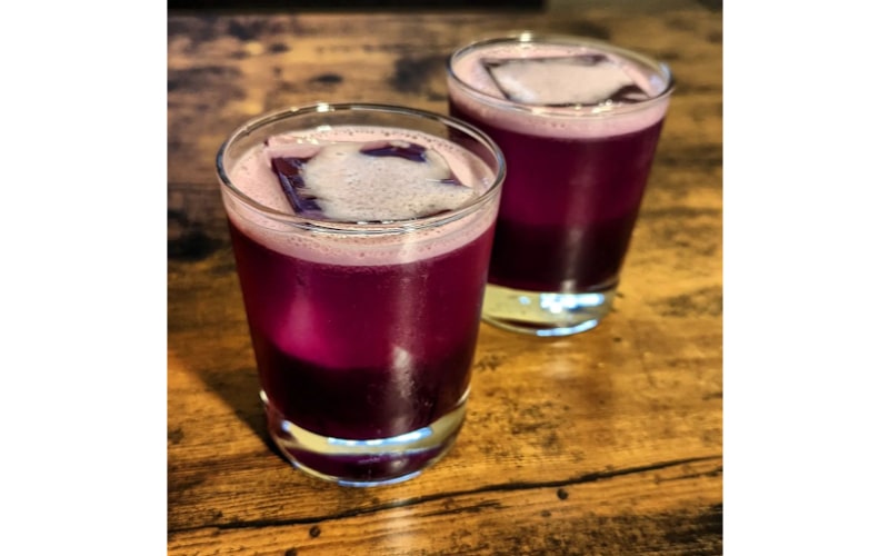 A glass of Purple Gin Sour