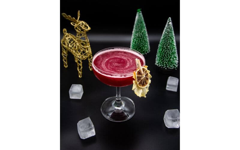A glass of Sleigh Ride with a reindeer and Christmas trees