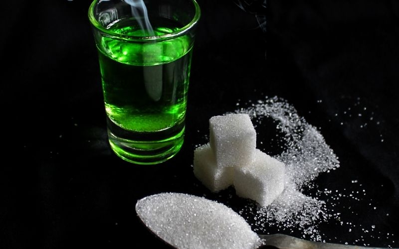 A glass of absinthe with sugar cubes