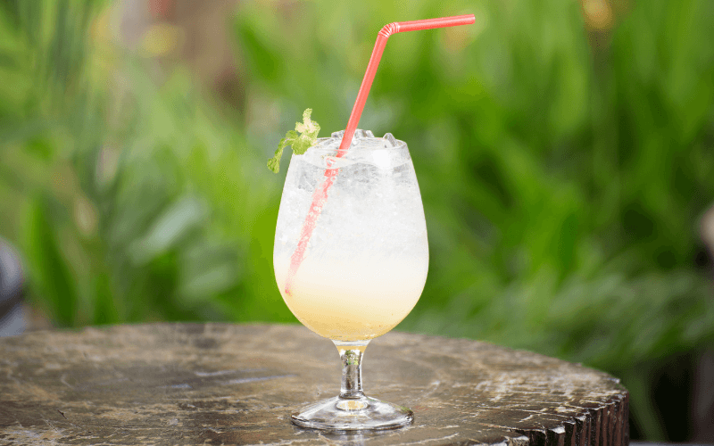 A glass of apple soda on a wooden table