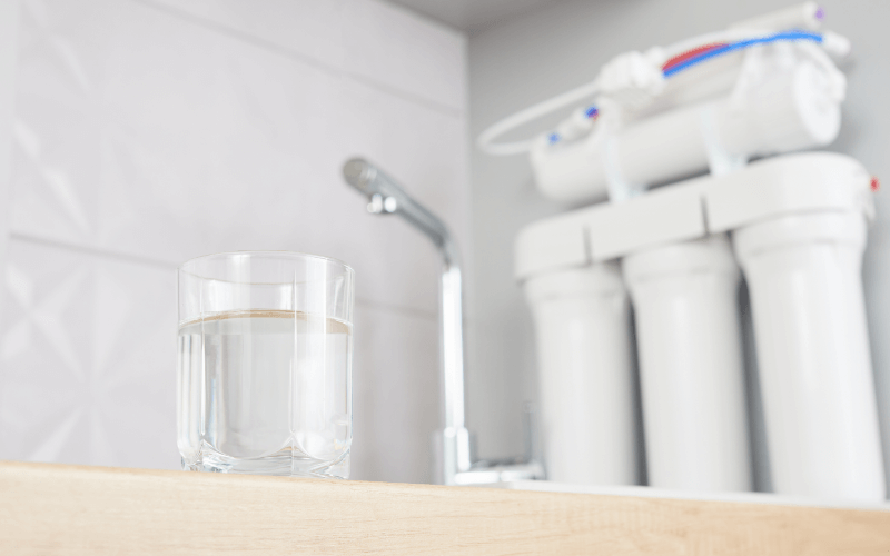 A glass of clean water with an osmosis filter in a kitchen interior