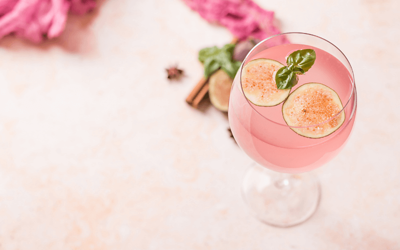 A glass of musk sticks margarita in a light pink background