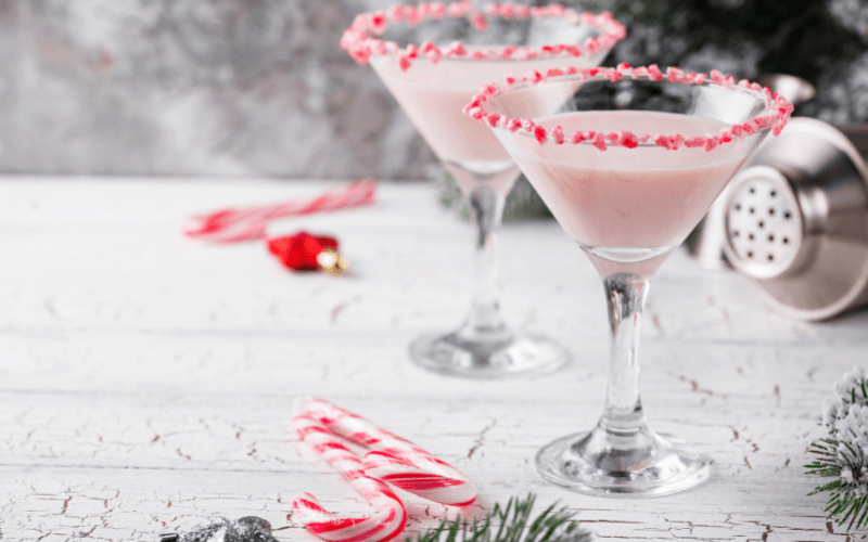 A glass of pink peppermint martini in a Christmas background