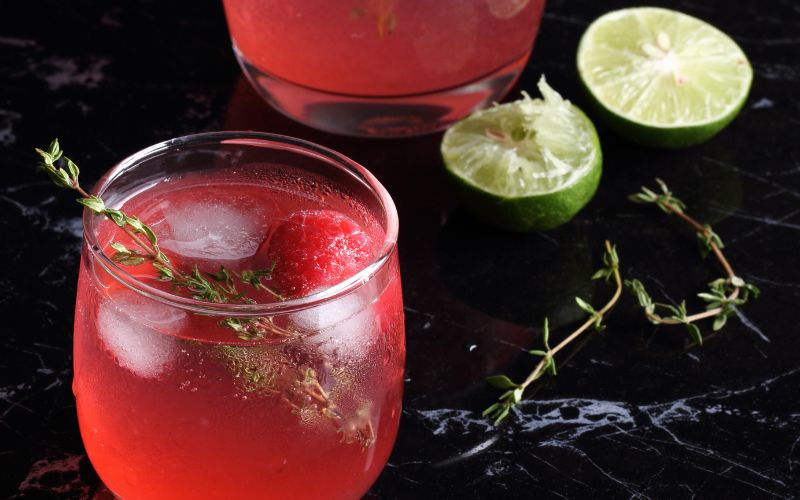 A glass of raspberry limoncello on a dark background