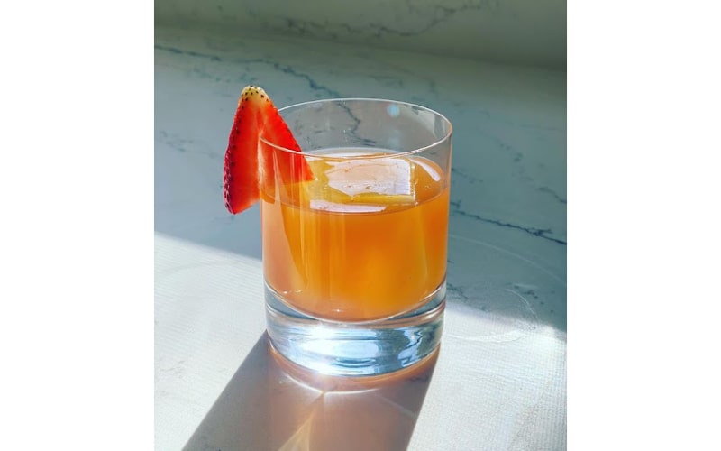 A glass serving of Cabin Fever drink with strawberry slice garnish