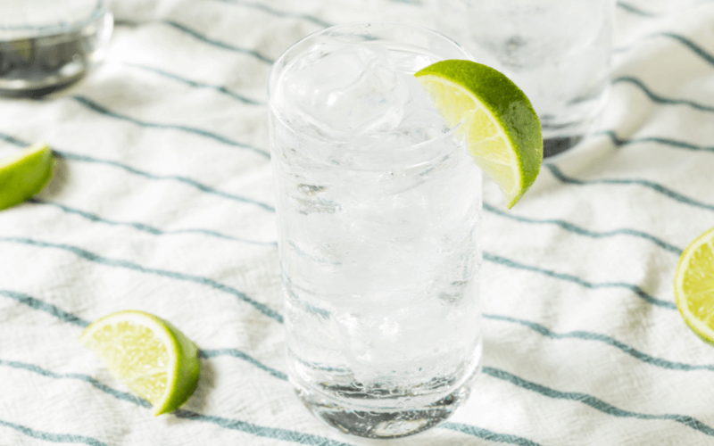 A highball glass of ranch water tequila cocktail with limes