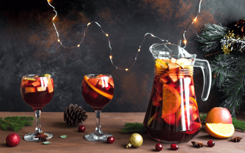 A pitcher and glasses of christmas sangria in a dark background