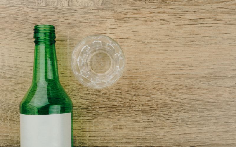 A soju bottle beside glass
