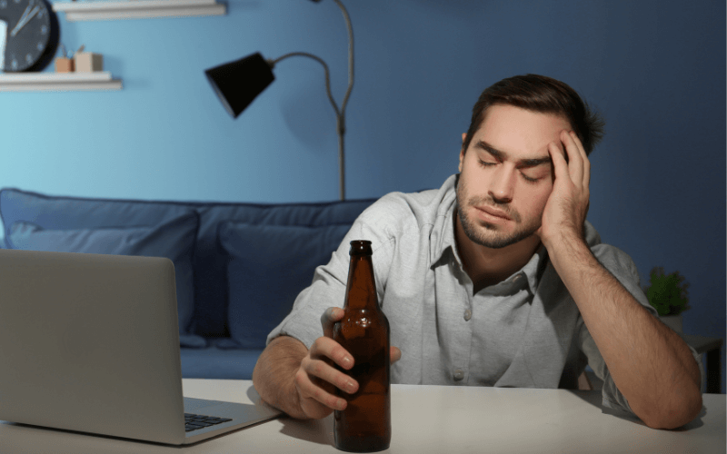 A tired and stressed man with a bottle of beer