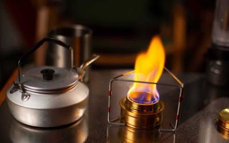 Alcohol stove beside a kettle