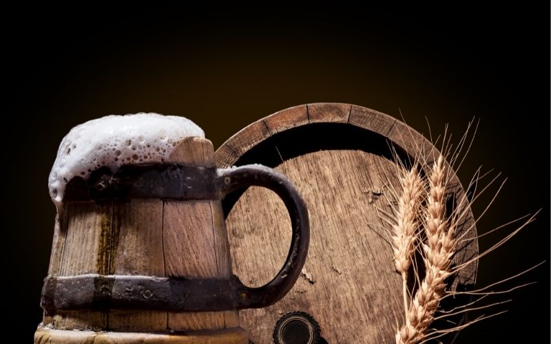 Ancient wooden pint with beer on dark background