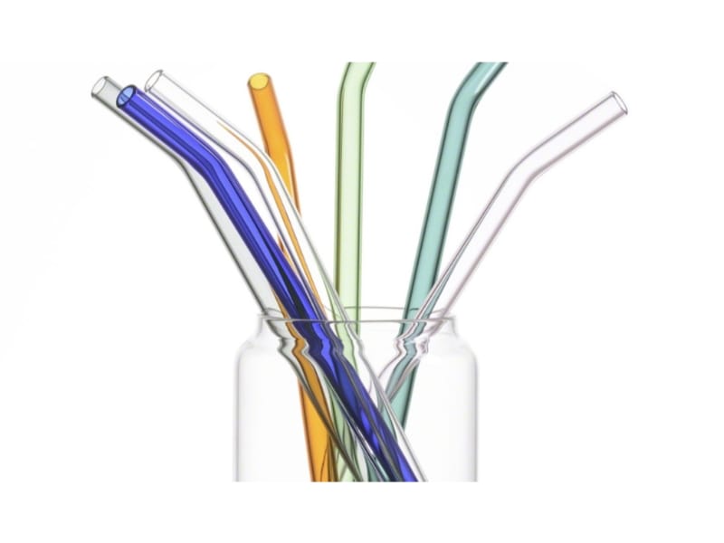 Various colored glass straws in a glass container