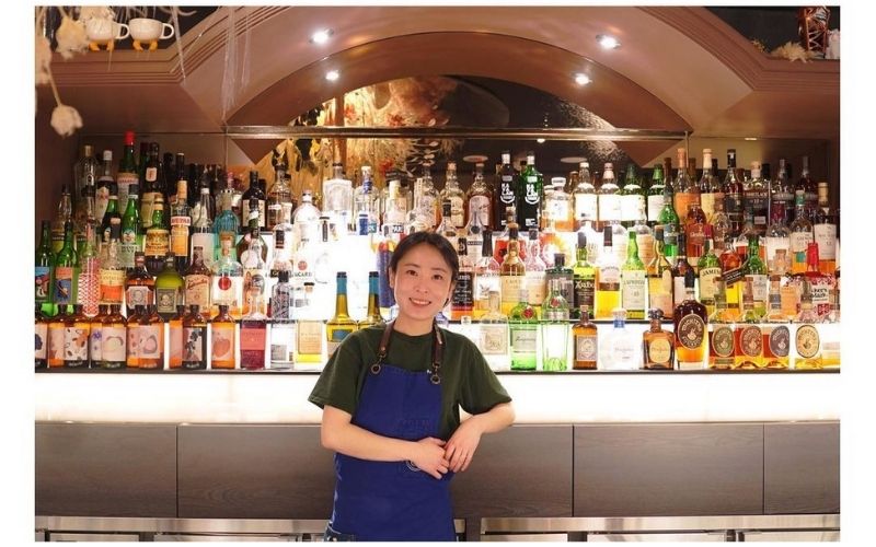 Bannie Kang in front of the bar