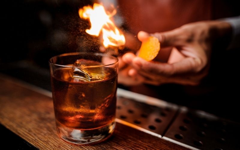 Bartender makes flame above a cocktail