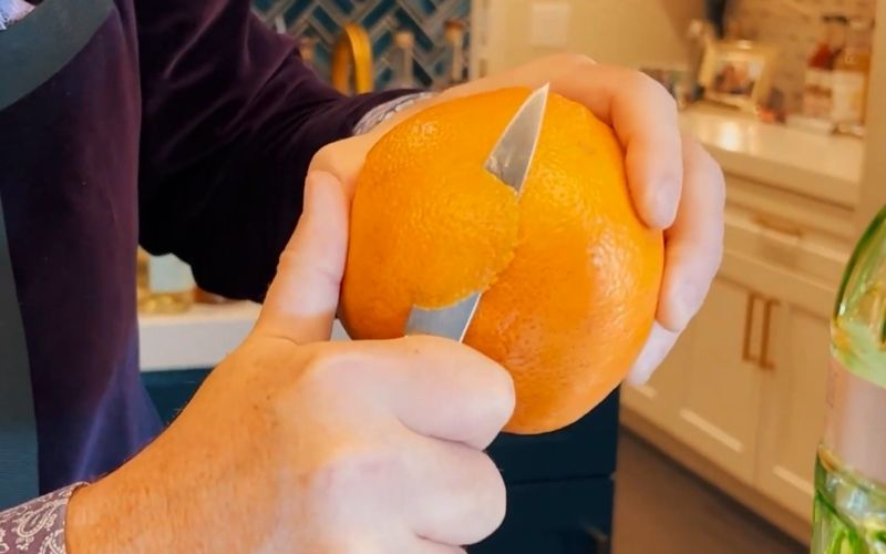 Bartender peeling a citrus peel 