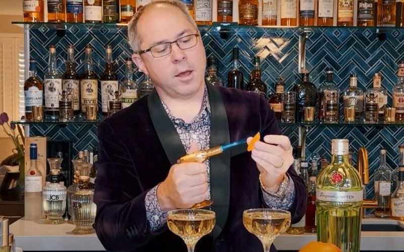 Bartender preheating a citrus rind with a torch