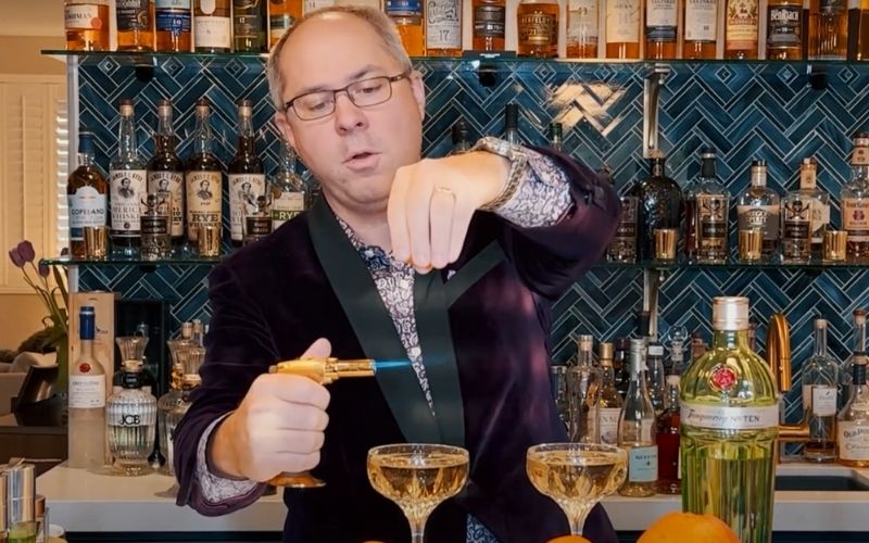 Bartending positioning the fire and citrus over a cocktail