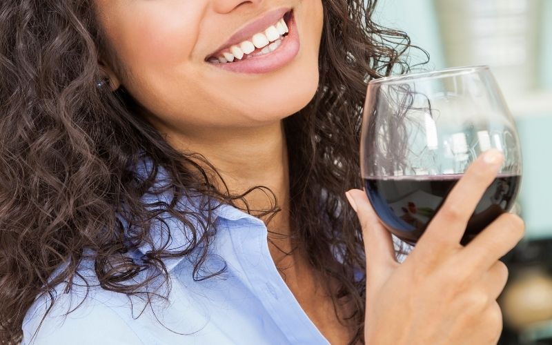 Woman smiling while holding a glass of wine