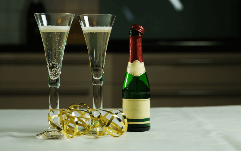 Bottle of Champagne beside two glasses 