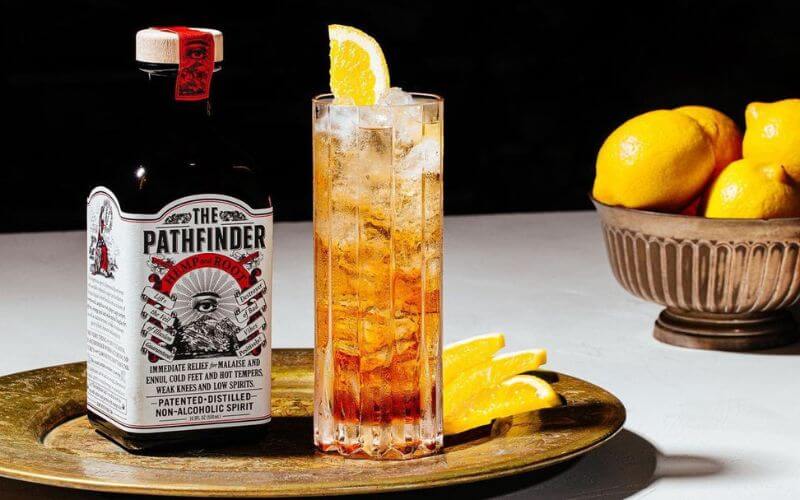 Bottle of The Pathfinder with a mocktail and lemons