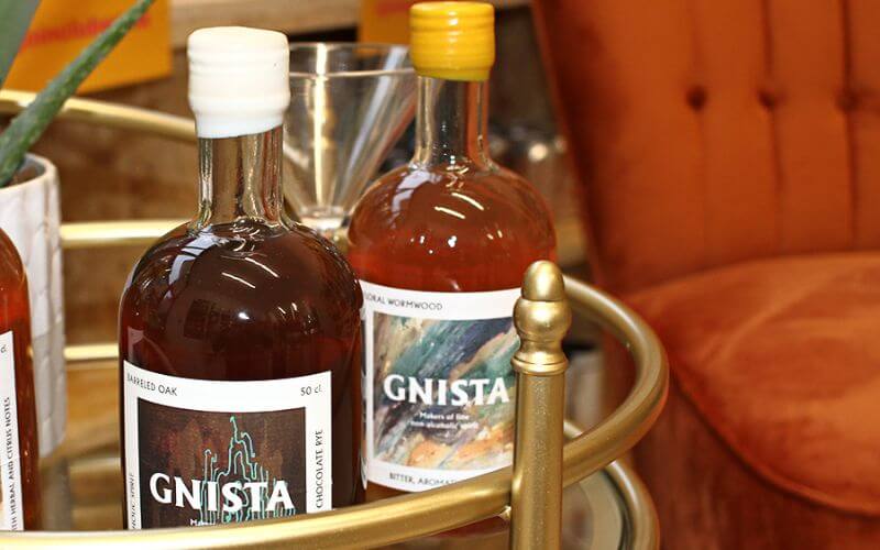 Bottles of GNISTA Spirits on a bar cart