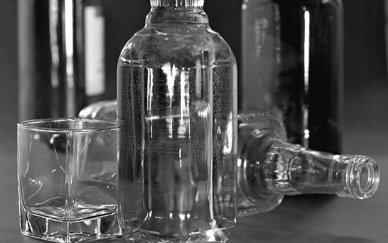 Bottles of grain alcohol and a glass