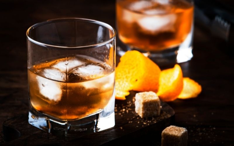 Bourbon cocktail with sugar cubes and orange zest