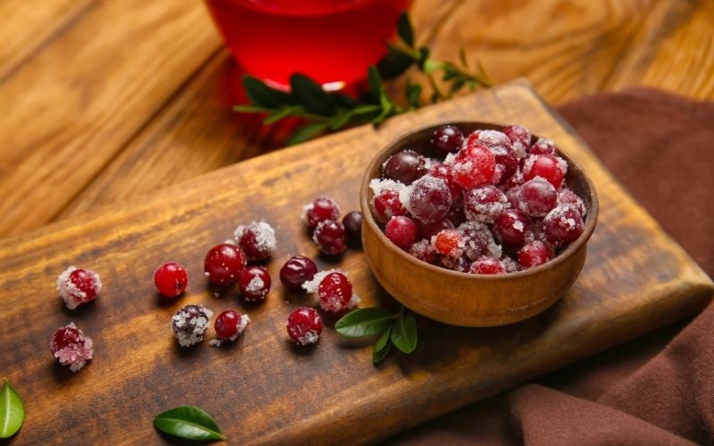 Bowl with Tasty Sugared Cranberries on Wooden Background
