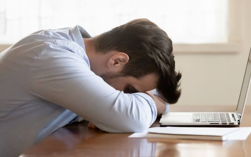 Boy sleeping on the desk with laptop on