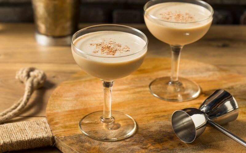 Brandy Alexander Cocktail with a jigger ion a wooden board