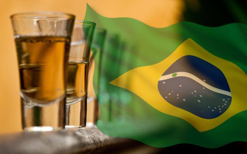 Cachaca in shot glasses beside the Brazil flag