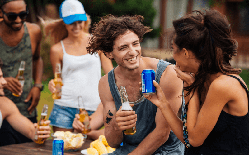 Friends having fun while drinking beer outdoors