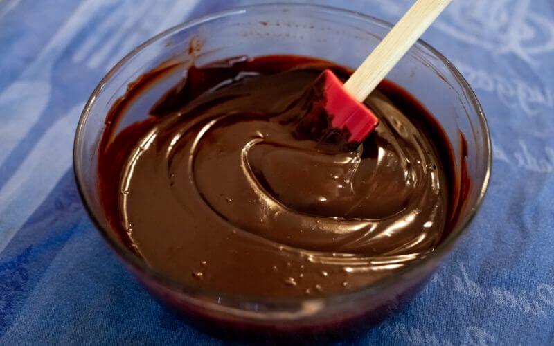 Chocolate ganache in a bowl with a spatula