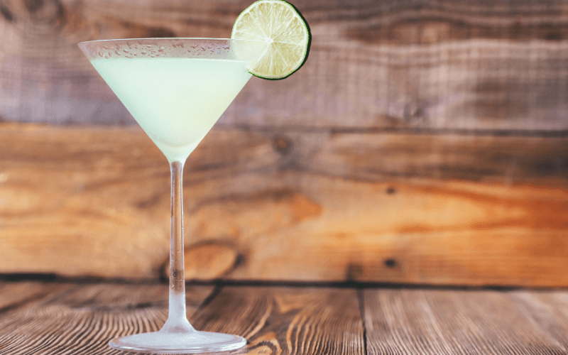A glass of classic daiquiri with a lime wedge