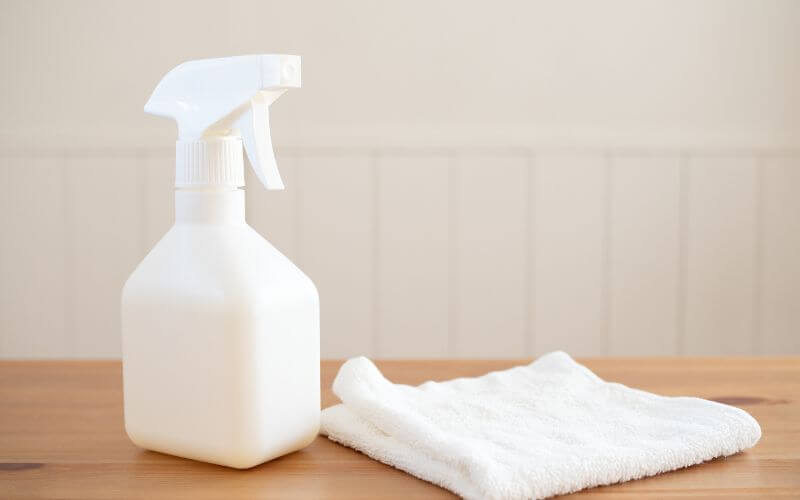 Cleaning spray bottle and towel on a table