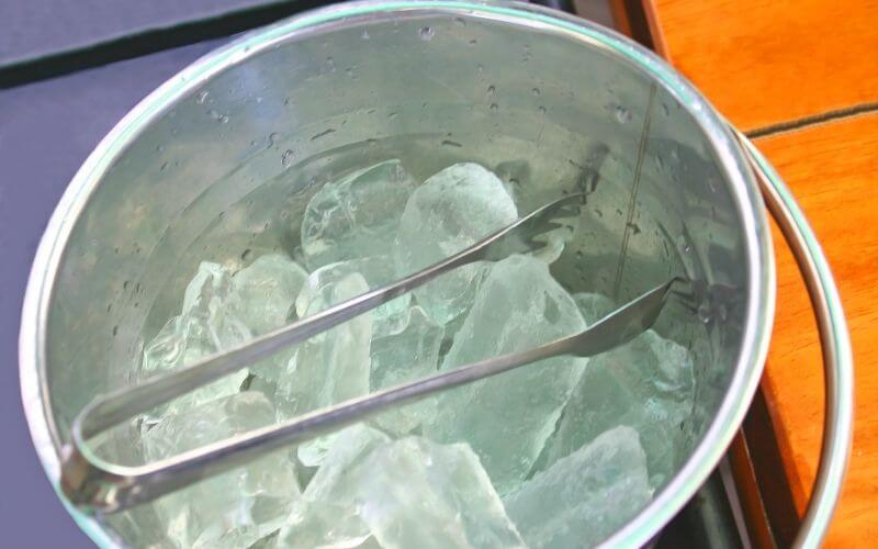 Closeup of ice bucket with tongs