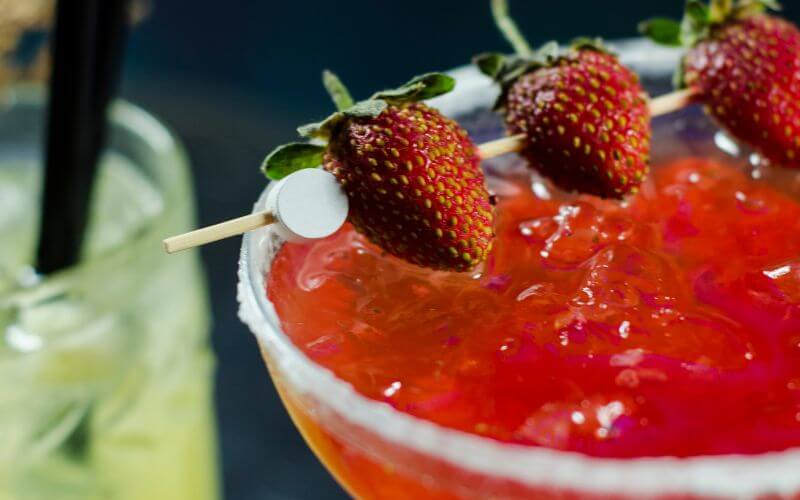 Cocktail with strawberry garnish in a skewer