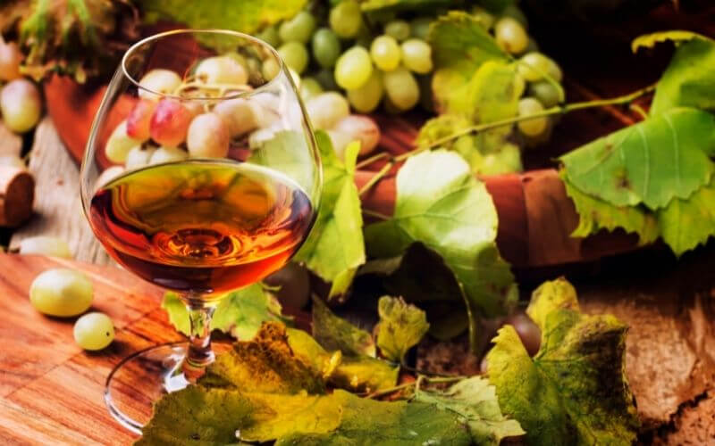 Cognac In Glass, Grapes, And Vine