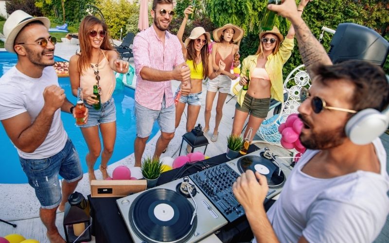 DJ playing music with people dancing at a garden party