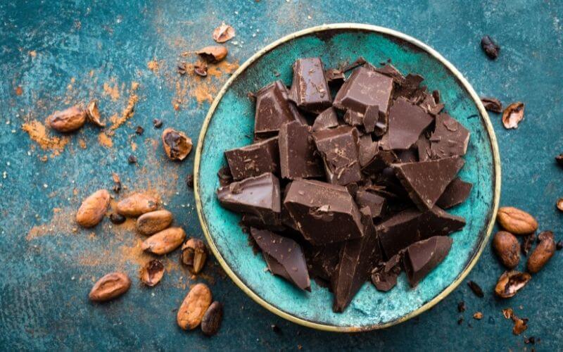 Dark bitter chocolate chunks in a blue bowl