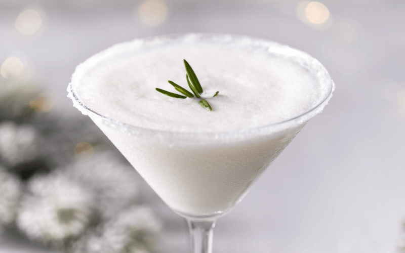A glass of driven snow cocktail in a white background