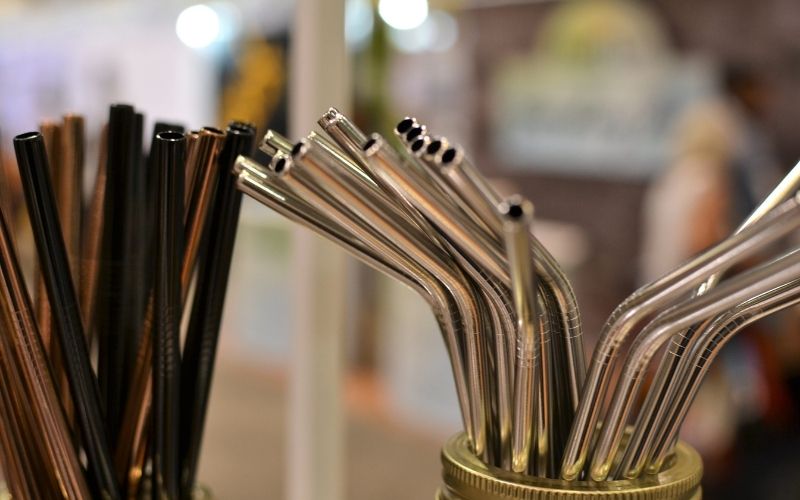 A bunch of stainless steel straws in glass jars