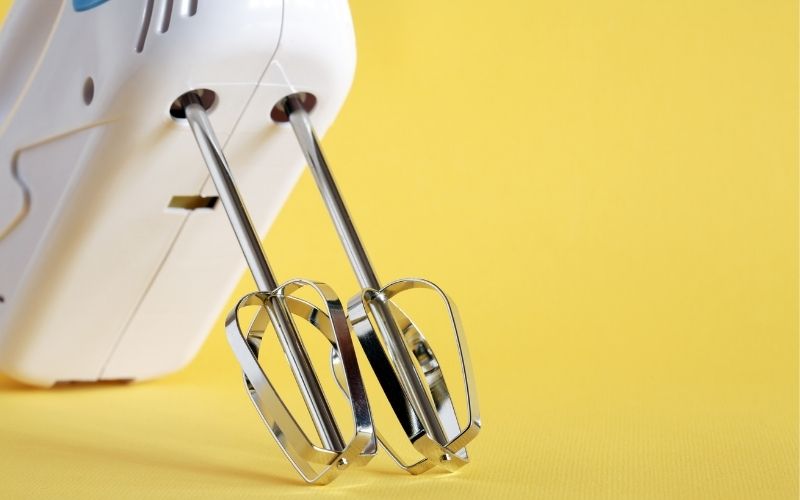 Electric mixer in yellow background