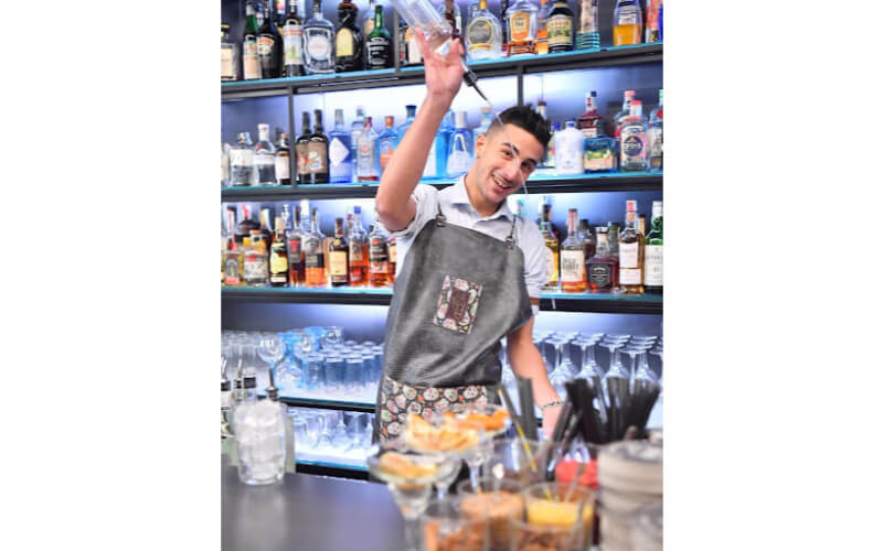 Enrico Fiore pouring liquor behind a bar