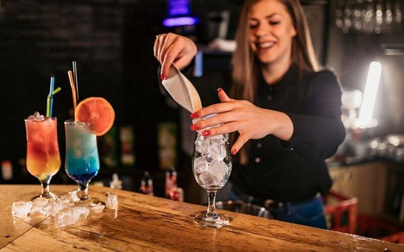 Female bartender making cocktails
